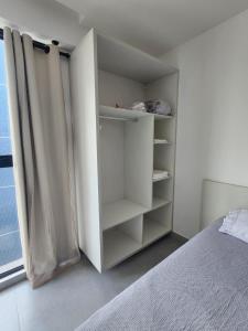 a white bedroom with a bed and a curtain at Apartamento Flat, Incrível, 250 M da Praia in Cabedelo +22 photos
