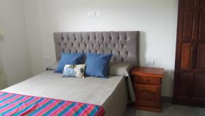 una camera da letto con un letto con cuscini blu di Cabañas Tafi a Tafí del Valle