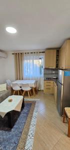 a living room with a table and a kitchen with a tablektop at Aliaj Guest House in Berat +39 photos