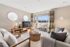 a living room with a couch and a table at Paihia 2 Bedroom Apartment with Pool in Paihia