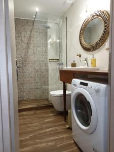 a bathroom with a shower and a washing machine at Nikola's & Joanna's apartments in Argostoli