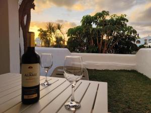 Una botella de vino y dos copas de vino en una mesa en FAIRWAYS CLUB, suite B37, en San Miguel de Abona