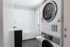 a bathroom with a toilet and a washing machine at Paihia 2 Bedroom Apartment with Pool in Paihia