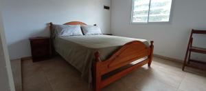 ein Schlafzimmer mit einem Bett in einem Zimmer mit einem Fenster in der Unterkunft Chalet a 500mts del mar in Mar del Tuyú