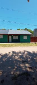 ein grünes Gebäude mit grauem Dach neben einer Straße in der Unterkunft Chalet a 500mts del mar in Mar del Tuyú