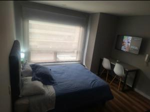a bedroom with a bed in front of a window at Loft centro internacional in Bogotá