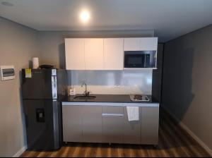 a small kitchen with a sink and a refrigerator at Loft centro internacional in Bogotá
