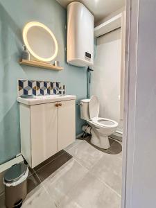 a bathroom with a toilet and a sink and a mirror at Le Cocon du Pérot in La Rochelle