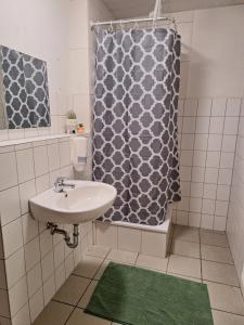 een badkamer met een wastafel en een douchegordijn bij Gästezimmer 2 in Mönchengladbach
