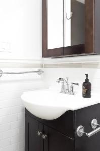a bathroom with a white sink and two mirrors at Purple Serenity at Brooklyn in Brooklyn