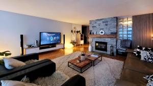 a living room with a couch and a fireplace at L'AvantGardiste, Spacious 6 bedrooms duplex, panoramic view in Crans-Montana