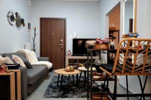 a living room with a couch and a tv at Happy Stay in Larisa