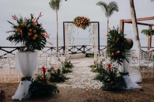 a wedding aisle with white chairs and flowers at Costa Sur All Inclusive Classico Collection by Sonesta in Puerto Vallarta +117 photos