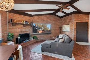 a living room with a couch and a brick wall at Rancho del Plata in Tucson
