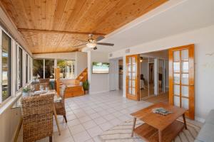 a living room with a ceiling fan and a table at Gulf front with sand and water access in Cedar Key