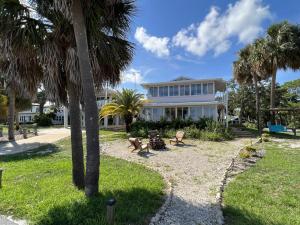 a house with palm trees in front of it at Gulf front with sand and water access in Cedar Key