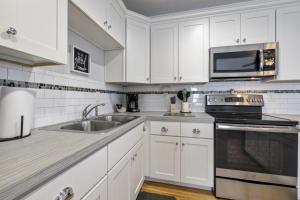 a white kitchen with a sink and a microwave at Beach Shack in Cedar Key +10 photos
