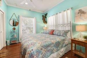 a bedroom with blue walls and a bed and a mirror at Pelican Place - Waterfront launch and fire pit in Cedar Key