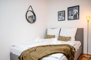 a bedroom with a bed with a mirror on the wall at Artful Apartment in Krefeld