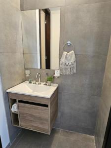 a bathroom with a sink and a mirror at Dpto paseo cibeles in Villa Carlos Paz