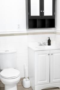a white bathroom with a toilet and a sink at Relaxx - 3Sunny Escape - Blue3057 in Brooklyn +4 photos