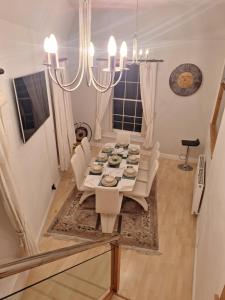 a dining room table with white chairs and a chandelier at Townhouse with 3 bathrooms in Edinburgh