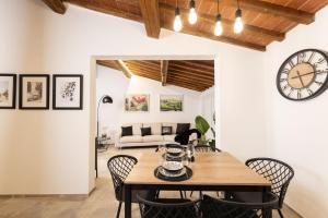 een eetkamer met een tafel, stoelen en een klok bij Loggia Senensis in Siena