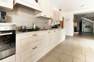 Una cocina grande con gabinetes blancos y piso de baldosas. en Villa Manuela by Rent Istria, en Babići 39 fotos más