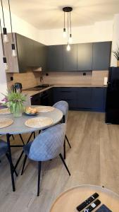 a kitchen with two tables and chairs and a sink at Apartament Stary Tartak in Ostróda