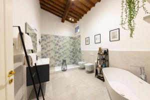 een badkamer met 2 toiletten, een bad en een wastafel bij Loggia Senensis in Siena +18 foto's