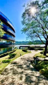 a building with a tree and a bench in front of it at Departamento en Veneto Village Resort y Spa in Villa Parque Siquiman