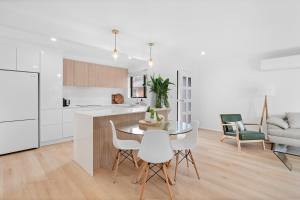 a kitchen and dining room with a table and chairs at Banksia Breeze Villa - 100m to North One Mile Beach in Forster