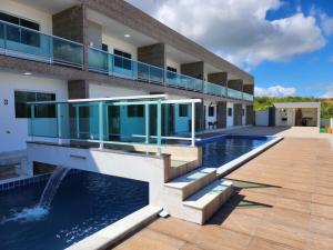 a house with a swimming pool and a building at Flat no Condominio Home Duplex Bezerros in Bezerros