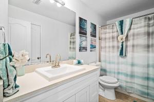 a white bathroom with a sink and a toilet at Game Room, Crib, Fenced Backyard, Relocation Stay in Frisco +28 photos