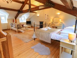 ein Schlafzimmer mit großem Bett und ein Wohnzimmer in der Unterkunft Daisy Cottage in Grasmere