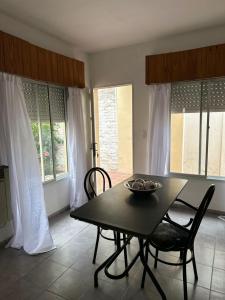 ein Esszimmer mit Tisch und Stühlen und Fenstern in der Unterkunft Lo de Nina in Villa María + 1 Foto