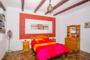 1 dormitorio con 1 cama colorida y vestidor en Apartamento Los 4 Nobles, en Tinajo