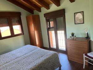 a bedroom with a bed and a dresser and windows at MIRADOR DE PEGUERINOS in Peguerinos
