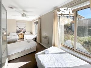 a hotel room with two beds and a window at Stonewall in Jindabyne