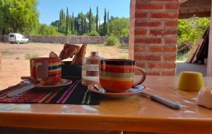 two cups of tea sitting on a table at La Cabaña hospedaje in Tilcara