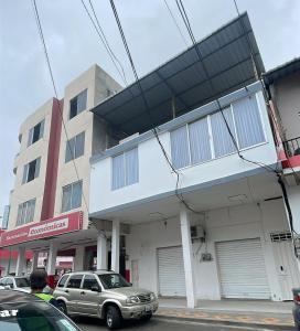 un coche aparcado delante de un edificio en SC Central Suite, en Manta
