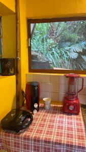 a kitchen counter with a red blender on a table at Chalé Laranja - Sítio Caldeirão in Posse