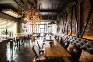 ein Restaurant mit Holztischen und -stühlen und einem Kronleuchter in der Unterkunft Bed Loft Cafe in Khon Kaen