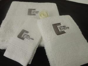 two white towels with a flower on them at Cantinho do Cantador in Riba de Mouro +40 photos