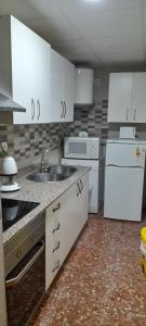 a kitchen with white cabinets and a sink and appliances at Alojamiento Rural Villa Baja - Castril in Castril