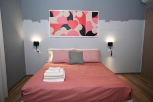 a pink bed with towels on it in a room at La Maison in Polla