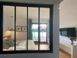 ein Zimmer mit Spiegel, einem Bett und einem Schlafzimmer in der Unterkunft L'escapage Vintage - Gîte - 2 chambres in Eschau + 27 Fotos