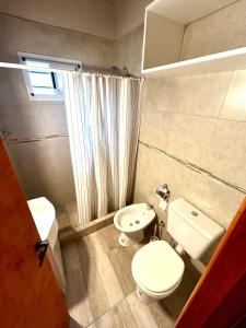 Un baño con un inodoro blanco y un lavabo. en Departamentos Norte 2, en Villa Gesell