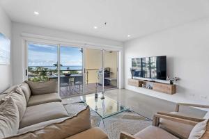 ein Wohnzimmer mit Sofa und Fernseher in der Unterkunft Beachfront - Flamingo Luxury 2BR condo - E423 in Palm-Eagle Beach