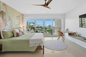 ein Schlafzimmer mit einem Bett und einem Fenster mit Aussicht in der Unterkunft Beachfront - Flamingo Luxury 2BR condo - E423 in Palm-Eagle Beach + 50 Fotos